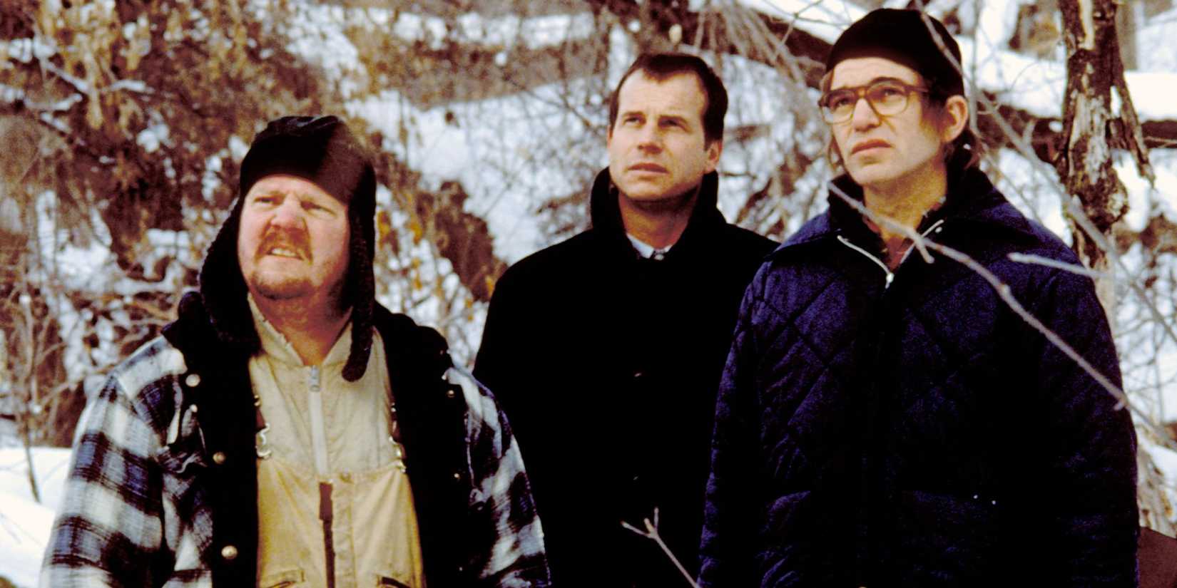 Lou, Hank, and Jacob standing in a snowy forest looking ahead in A Simple Plan