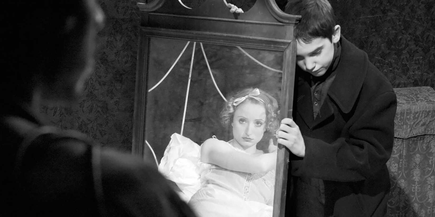 A boy holding a mirror in front of a woman in 'Brand Upon the Brain!'