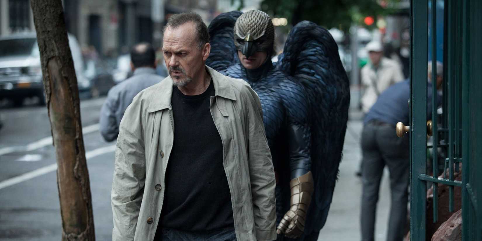 Michael Keaton as Riggan Thomson, walking down the street as Birdman follows behind him in Birdman.