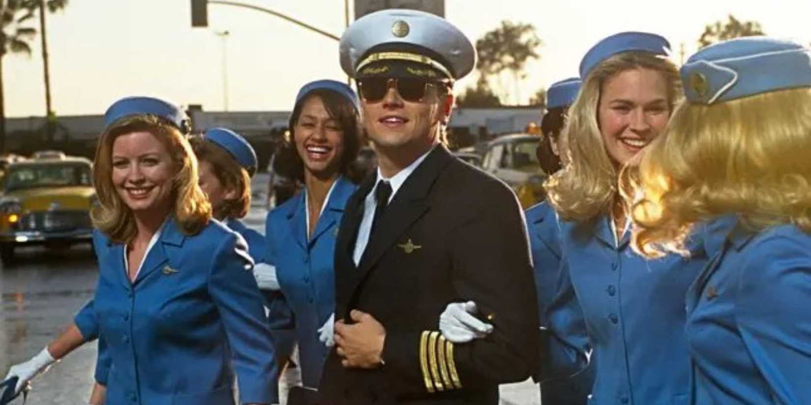 Leonardo DiCaprio smiling and walking with a group of female flight attendants in Catch Me If You Can (2002)