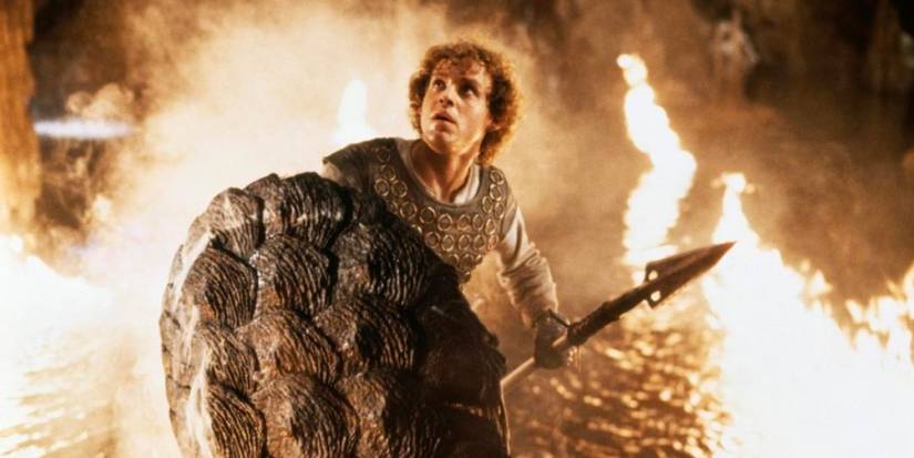 A young man with a spear and a shield surrounded by fire in Dragonslayer.