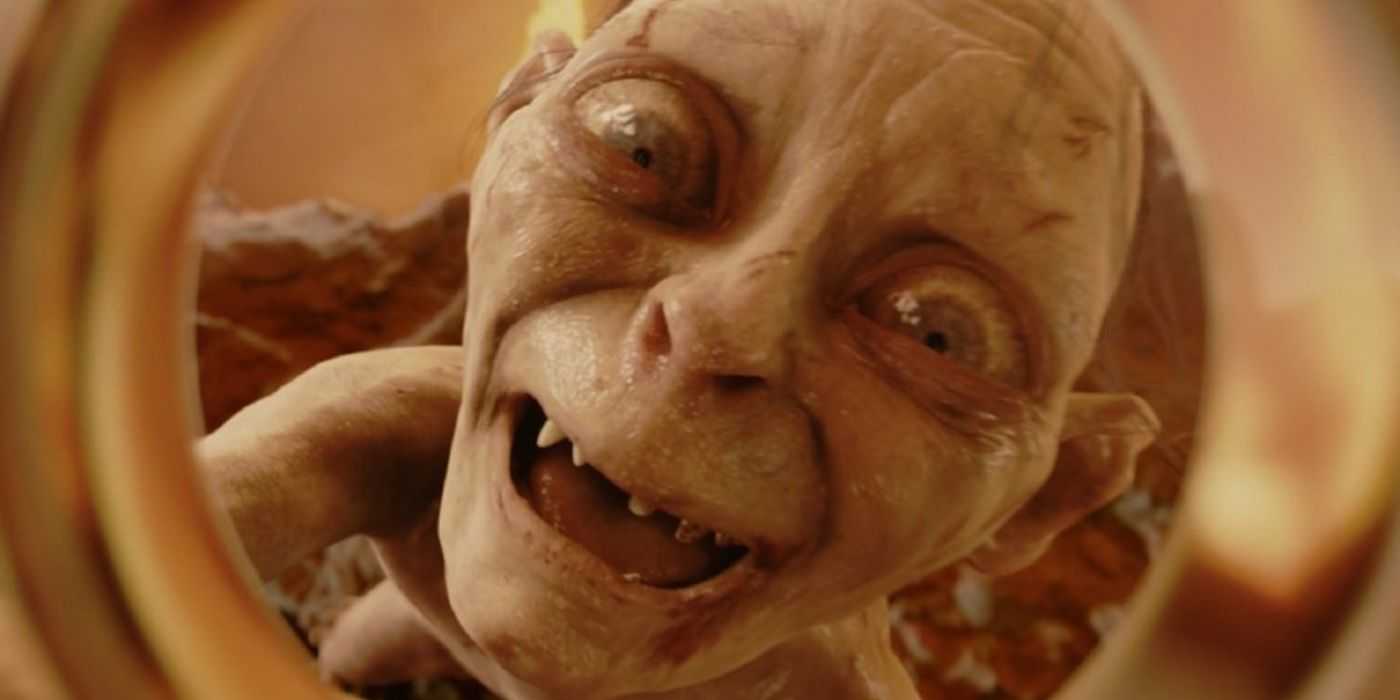 A still from The Return of the King of Gollum, played by Andy Serkis, smiling as he holds up the One Ring.