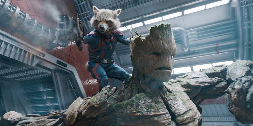 Rocket (Bradley Cooper)  stands on Groot (Vin Diesel) while shooting a gun in Guardians of the Galaxy 3