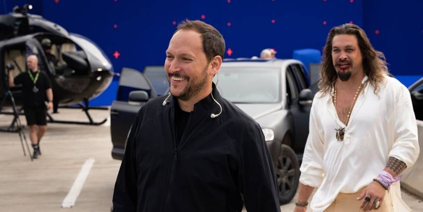 Director Louis Leterrier laughs on the set of Fast X with Jason Momoa in the background.