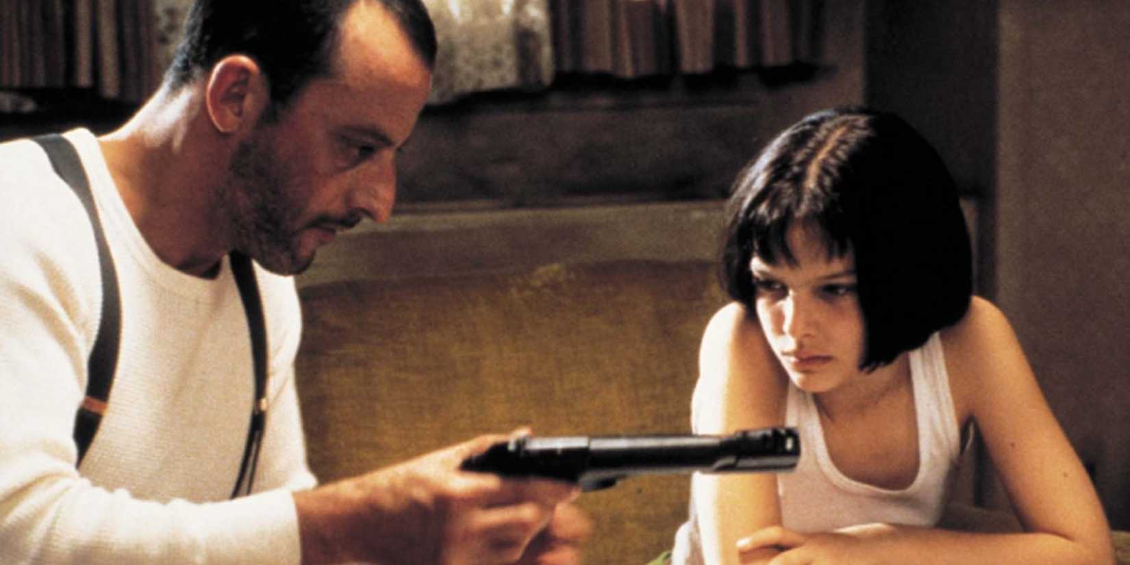 Léon (Jean Reno) teaches Mathilda (Natalie Portman) to use a gun in Léon: The Professional (1994)   