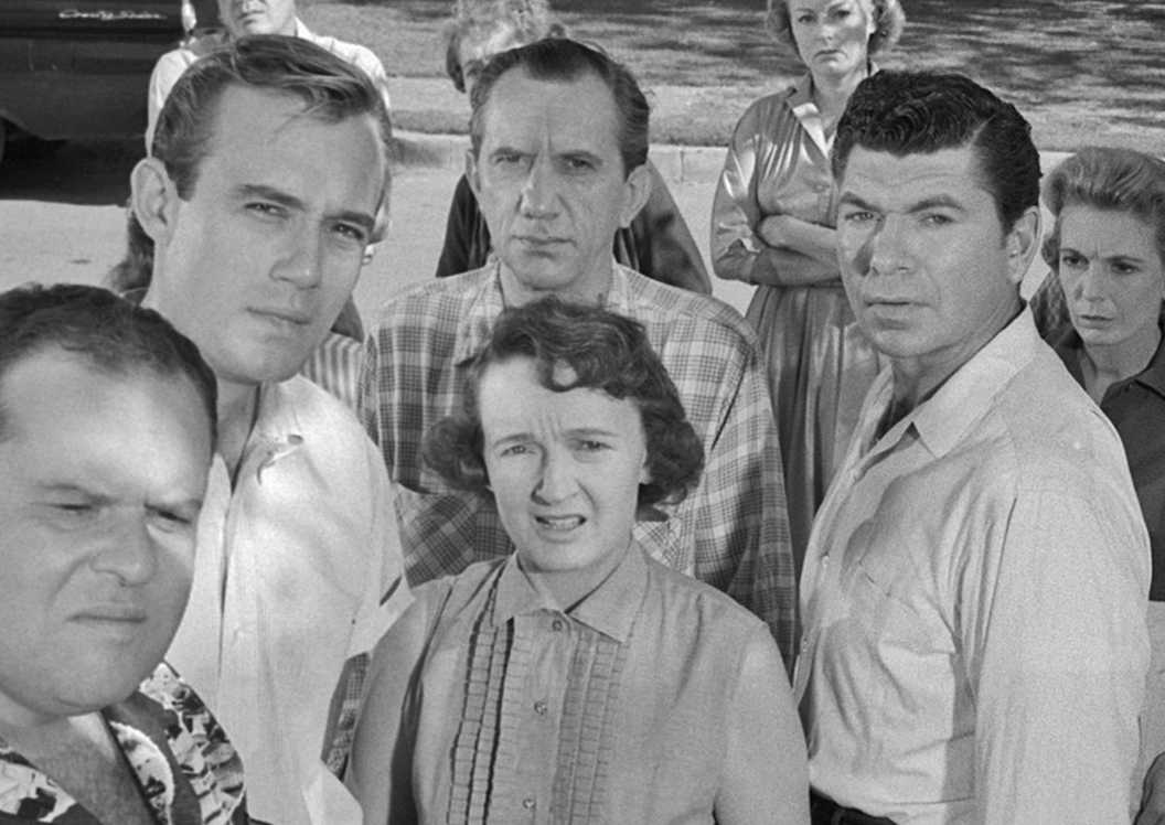 Neighbors gossip and stare at the viewer in The Monsters Are Due On Maple Street in The Twilight Zone.