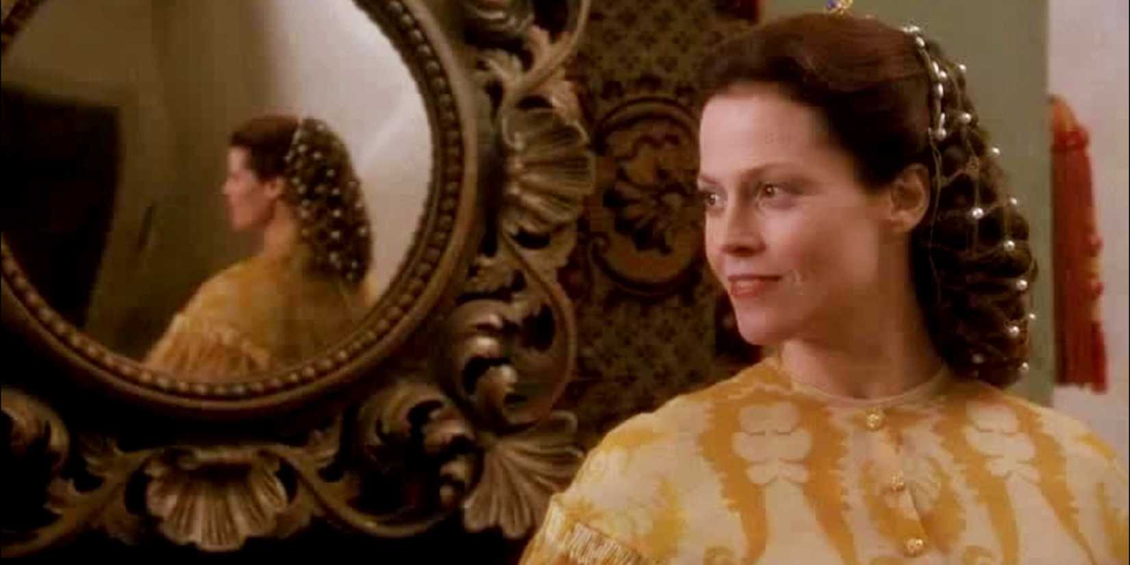 Sigourney Weaver as Claudia stands next to a mirror that shows her reflection in Snow White: A Tale of Terror