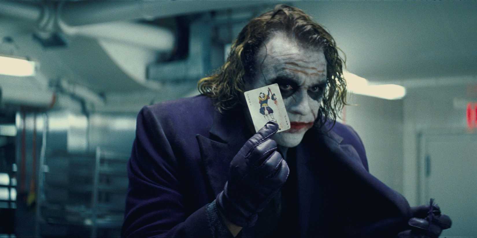 The Joker showing a Joker card in The Dark Knight