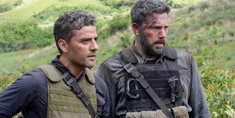 Oscar Isaac and Ben Affleck as Redfly and Pope looking in the same direction in Triple Frontier.