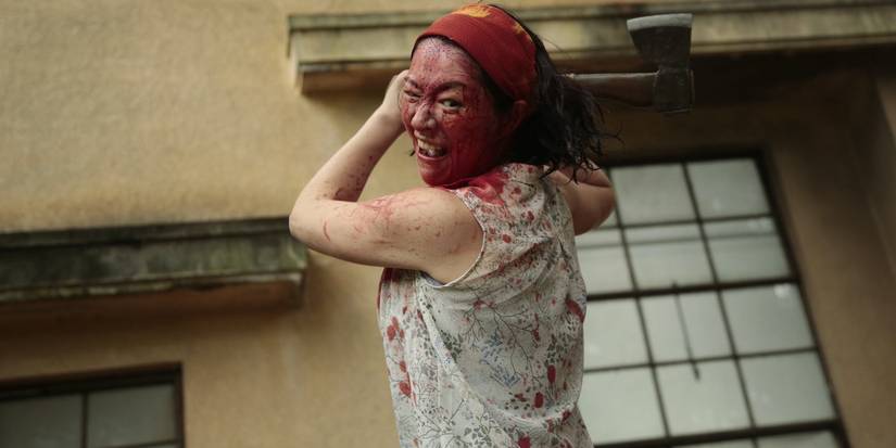 A woman with blood on her face swinging an axe in One Cut of the Dead