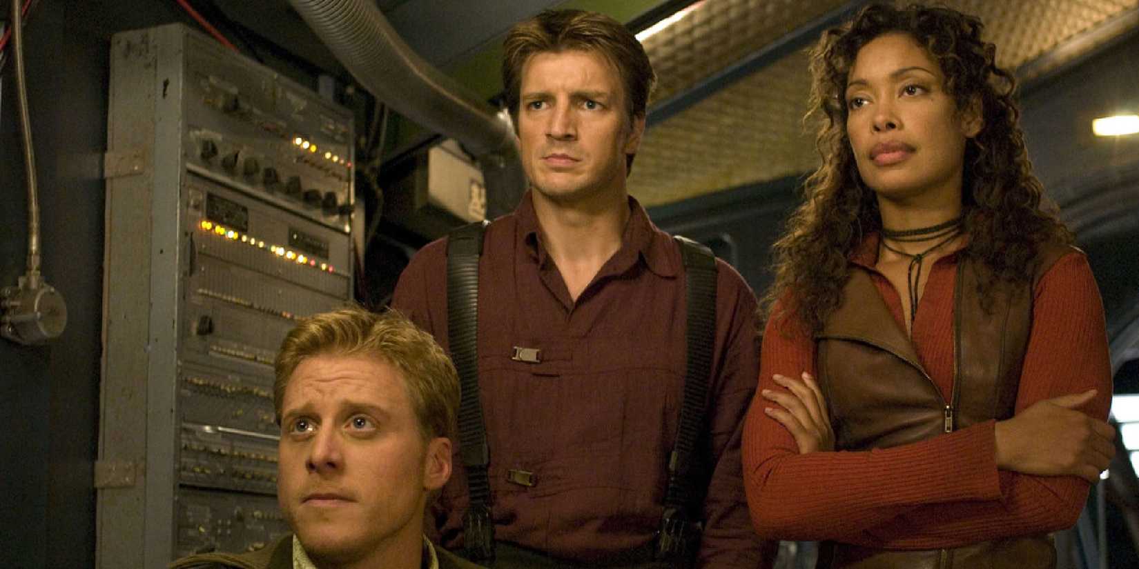 Alan Tudyk, Nathan Fillion & Gina Torres looking concerned at something in front of them in 'Firefly.'