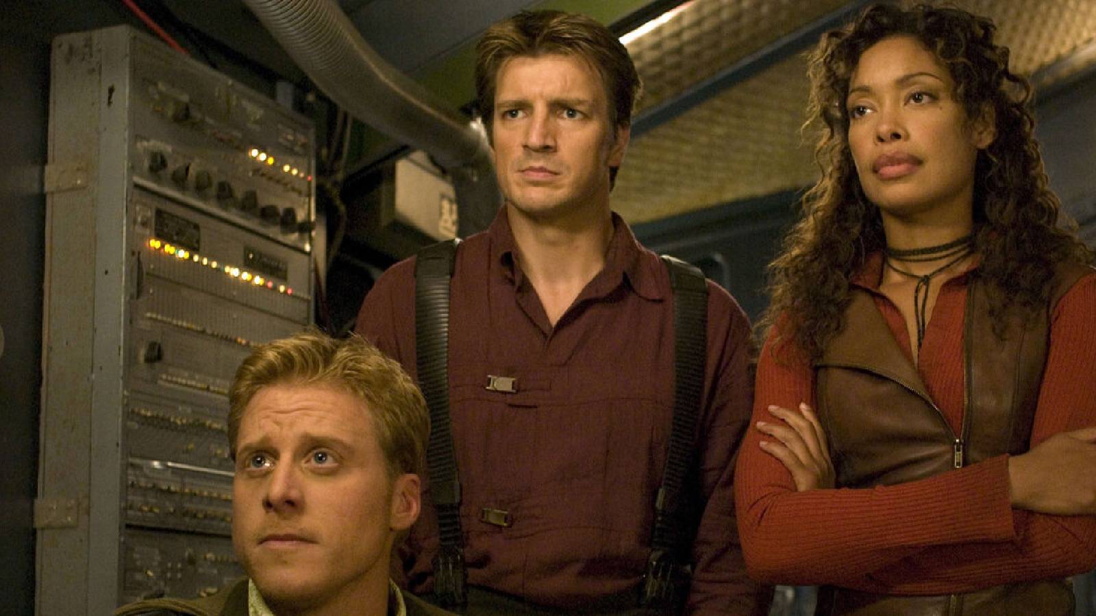 Alan Tudyk, Nathan Fillion & Gina Torres looking concerned at something in front of them in 'Firefly.'