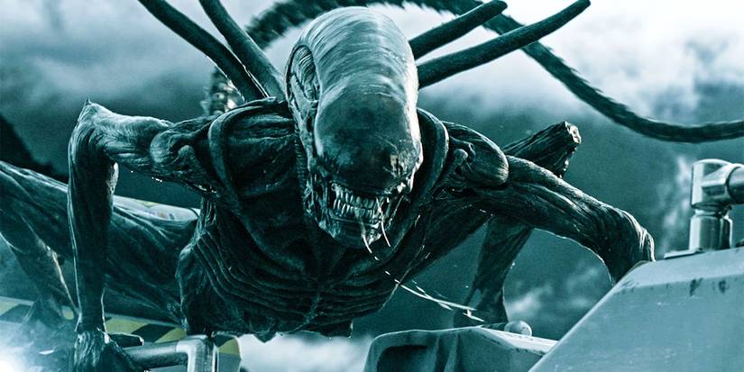 The xenomorph from the movie Alien: Covenant crouching and drooling outside a spaceship.