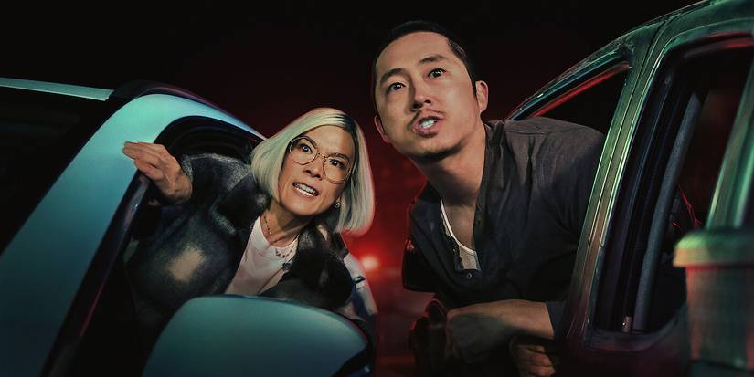 Ali Wong and Steven Yeun leaning out their vehicle windows in Beef. 