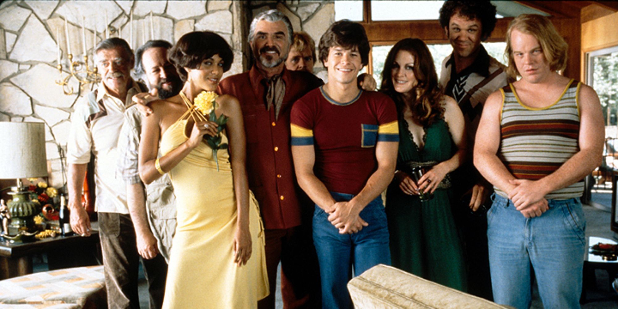 The cast of Boogie Nights takes group photo inside a period decorated home.