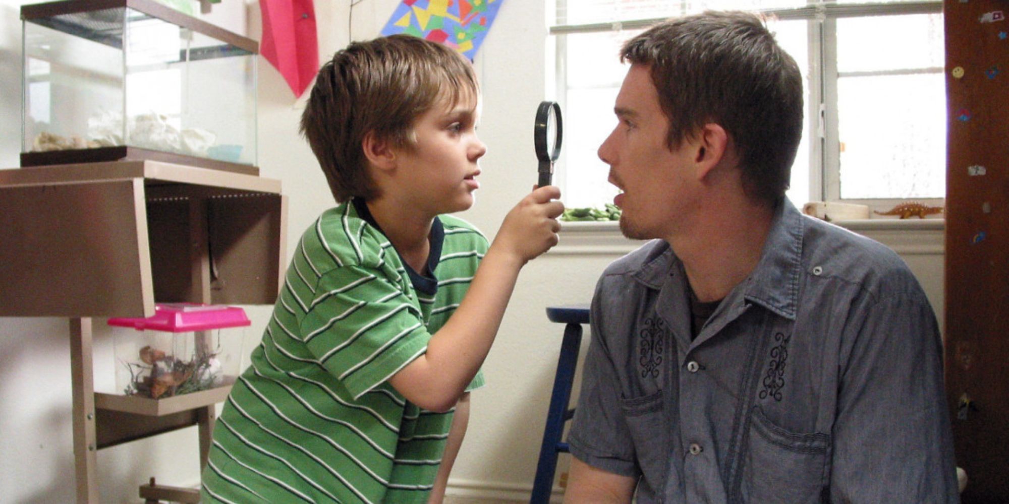 Mason Jr. looking at Mason Sr's face with a magnifying glass in Boyhood (2014)  (1)
