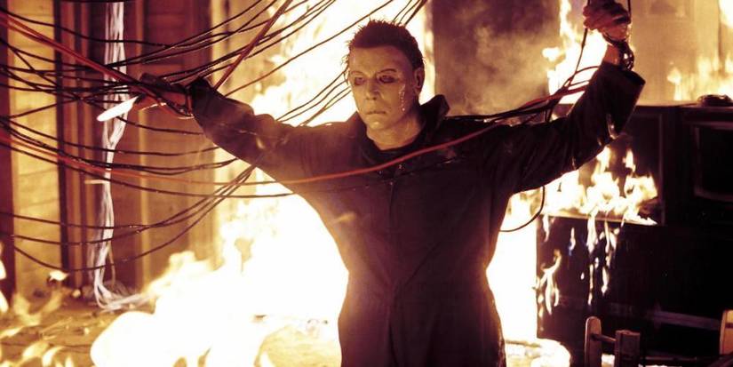 Michael Myers grabs onto some wires as flames surround him in 'Halloween: Resurrection'.