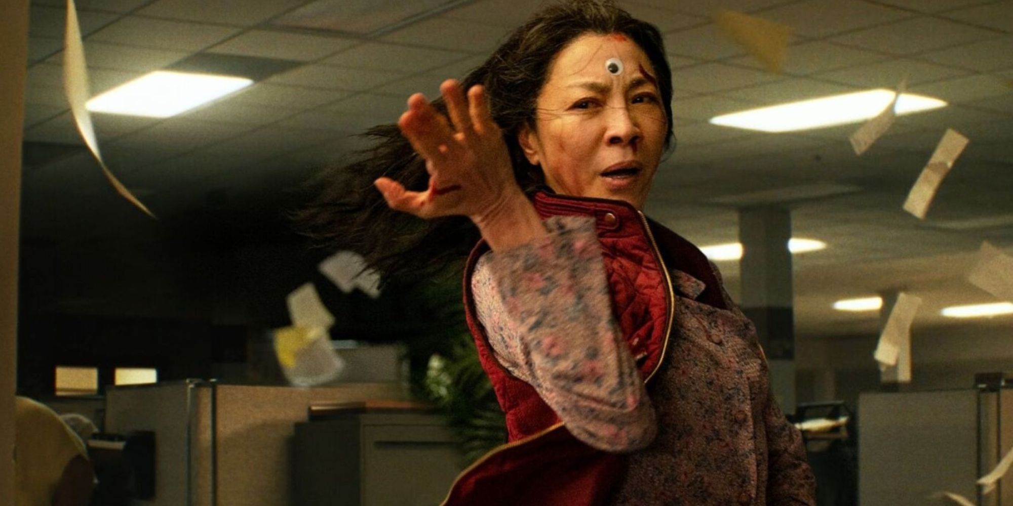 Evelyn, fighting while paper sheets fly around her in Everything Everywhere All at Once.