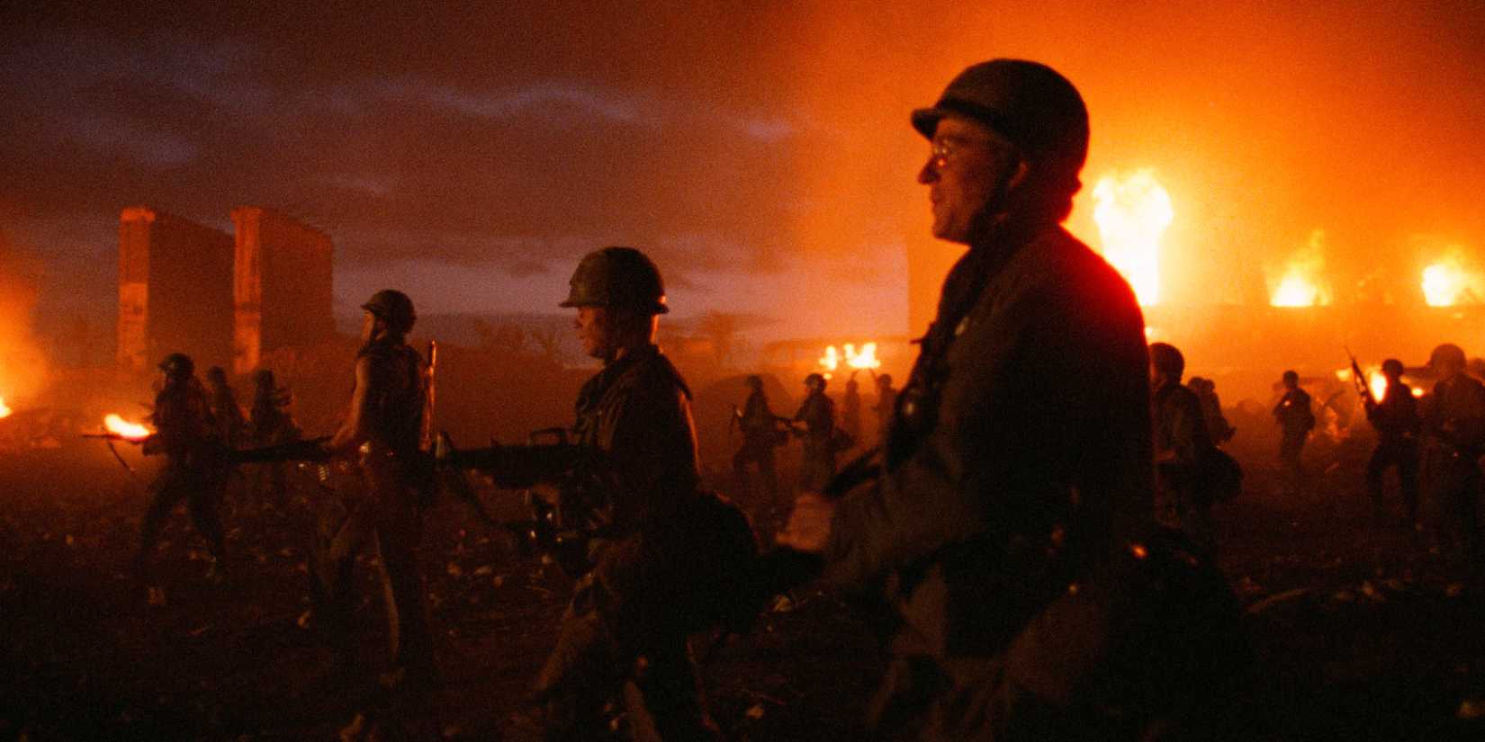 Joker (Matthew Modine) and other soldiers marching at night through Vietnam, lit by surrounding fires in Full Metal Jacket
