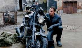 Nic Cage kneeling by a motorcycle in Ghost Rider: Spirit of Vengeance