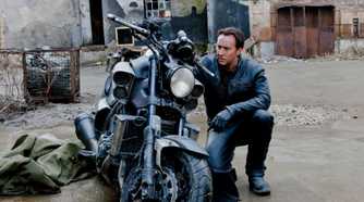 Nic Cage kneeling by a motorcycle in Ghost Rider: Spirit of Vengeance