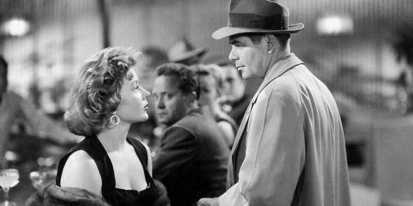 Glenn Ford looking at Gloria Grahame sitting in The Big Heat.