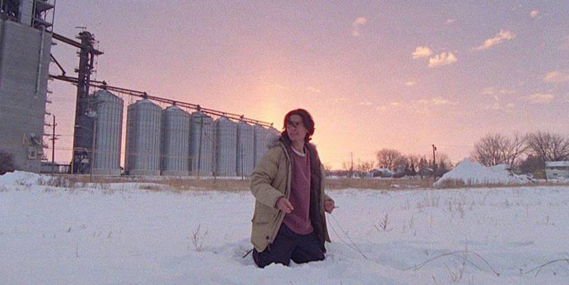 A man kneeling on the snow in How to Blow Up a Pipeline