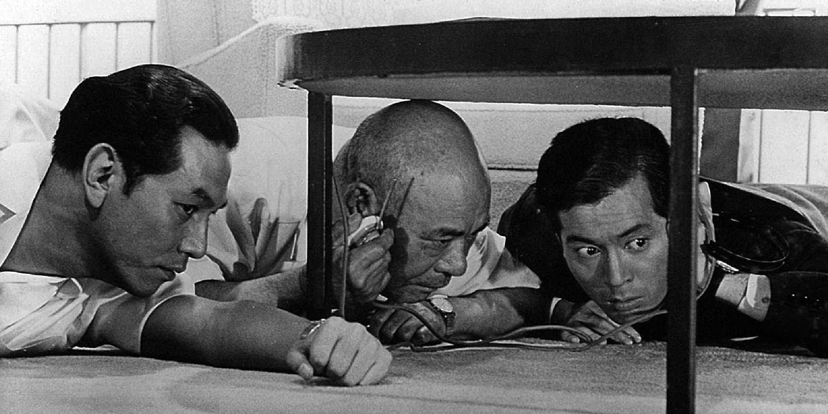 Kenjirô Ishiyama, Takeshi Katô, and Tatsuya Nakadai hiding under a table in High and Low