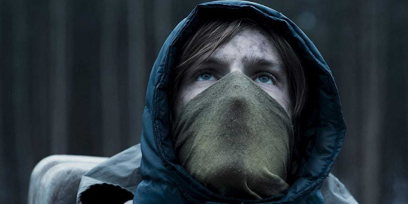 Louis Hofmann Jonas olarak karanlıkta maske takıyor ve bakıyor.