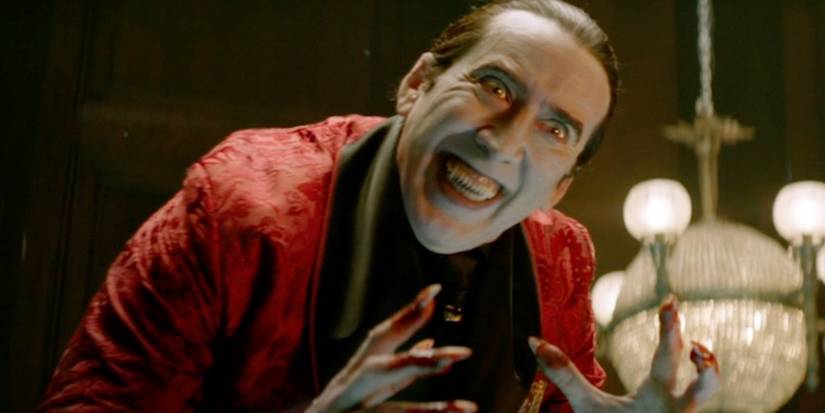 Nicolas Cage as Dracula smiling at one of his victims in Renfield.