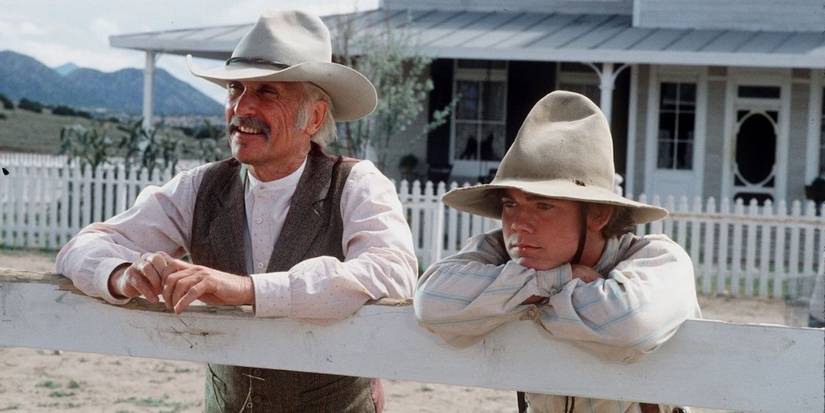 Robert Duvall and Ricky Schroder leaning against a fence in 1989's Lonesome Dove.