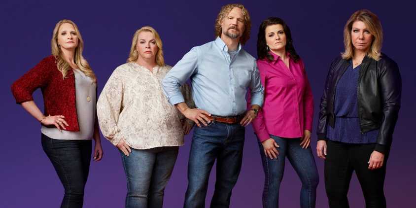 Sister Wives and Kody Brown in group studio photo with blue backdrop in 2023.