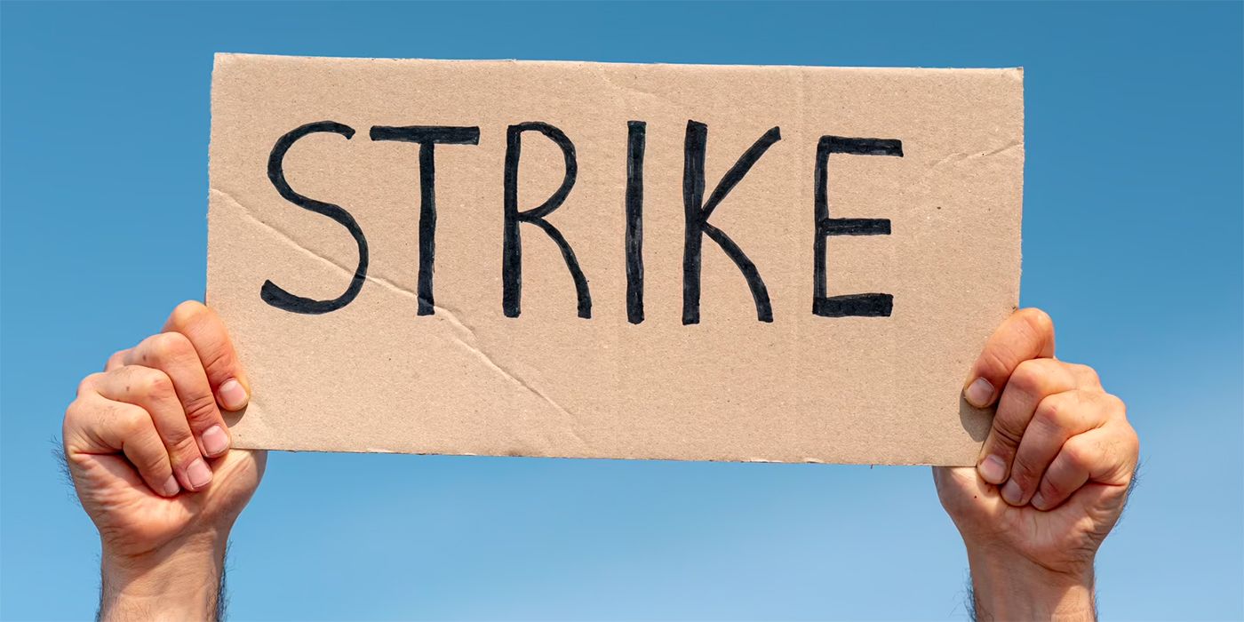 Stock image of a person holding a sign that says Strike