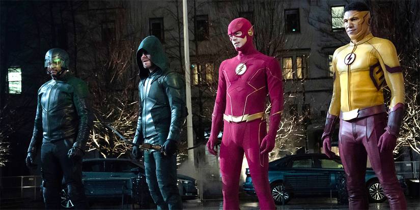 Diggle (David Ramsey), Oliver/Green Arrow (Stephen Amell), Barry/Flash (Grant Gustin), and Wally West/Kid Flash (Keiynan Lonsdale) standing in the street in costume in The Flash