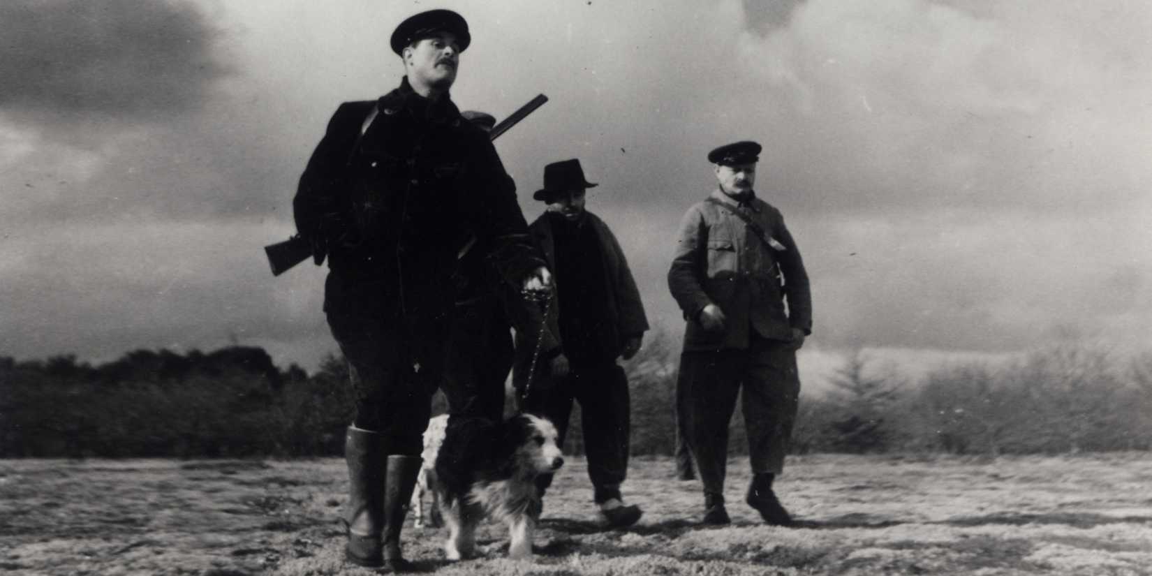 A group of soldiers walking through an open field in The Rules of the Game - 1939