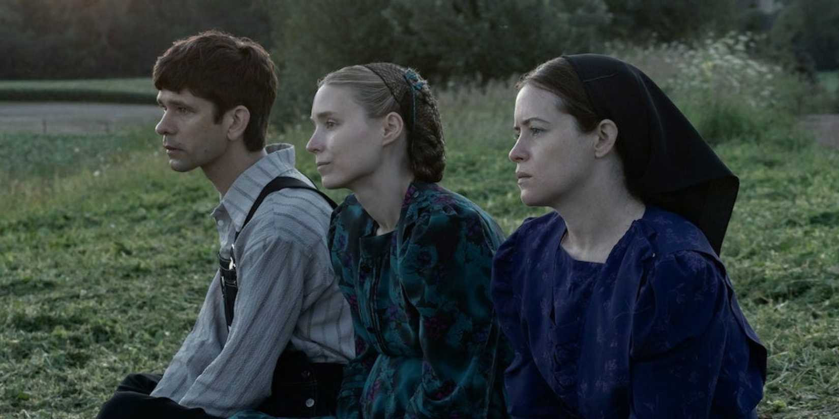 August, Ona, and Salome sitting down and looking to the distance in Women Talking (2022) 