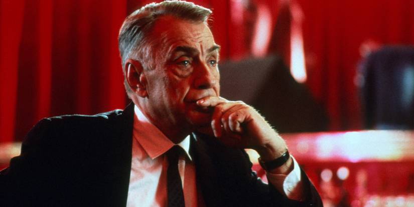Philip Baker Hall as Sydney sitting with his hand resting on his chin in Hard Eight.