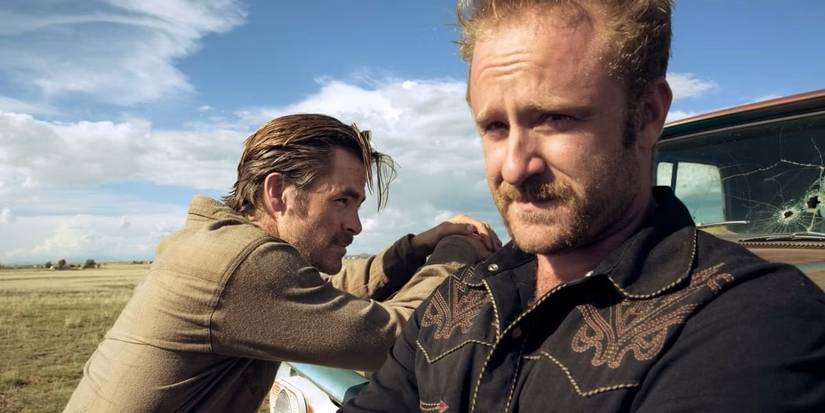 Ben Foster & Chris Pine lean against a bullet-riddled truck in the desert in Hell or High Water