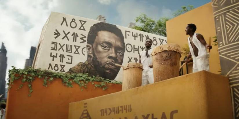 A painted mural with musicians nearby at T'Challa's funeral ceremony in Black Panther 2: Wakanda Forever.