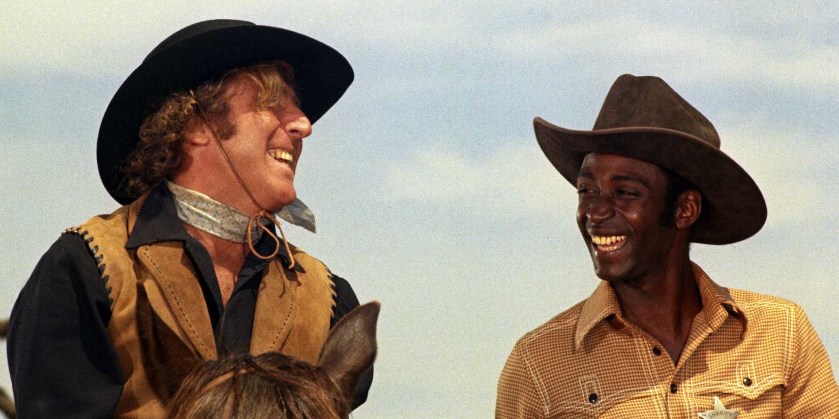 Gene Wilder and Cleavon Little as Jim the Waco Kid and Sheriff Bart laughing together in Blazing Saddles.