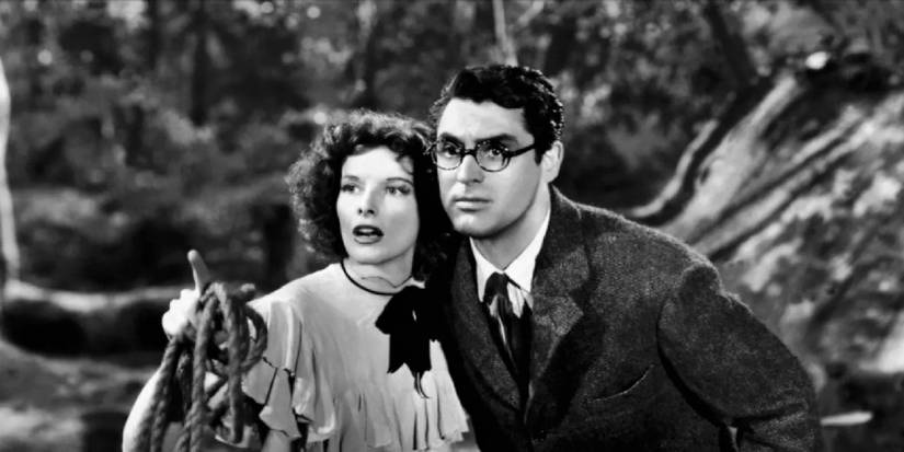 Katharine Hepburn points at something while standing next to Cary Grant outside in Bringing Up Baby, 1938.