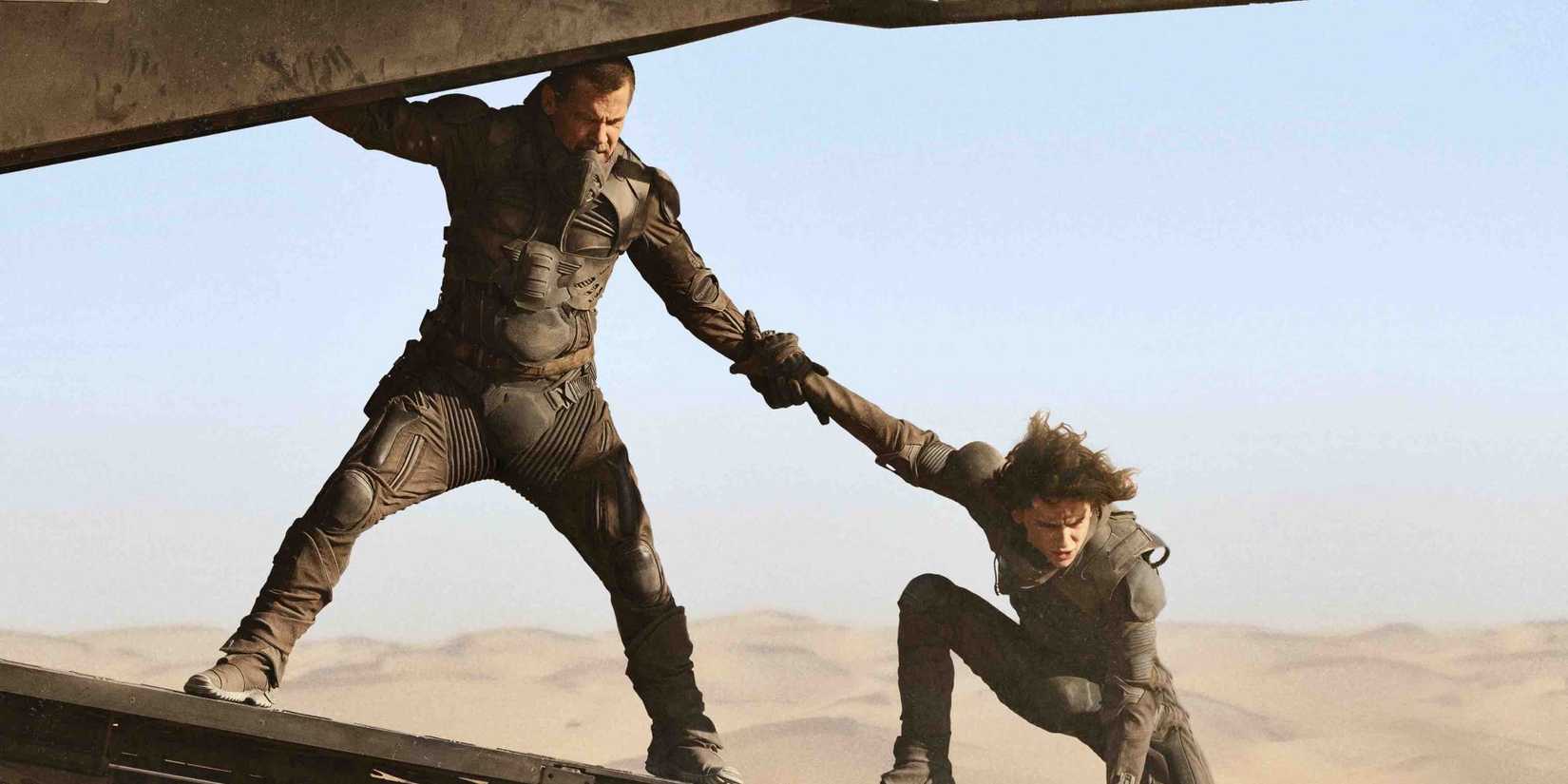 Gurney Halleck (Josh Brolin) helps Paul Atreides (Timothée Chalamet) board a ship in Dune, 2021.