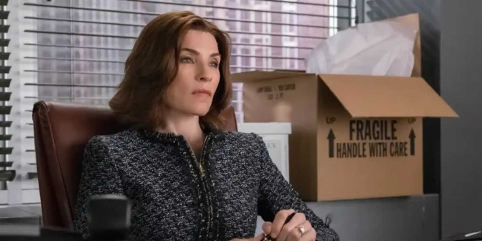 Julianna Margulies duduk bersila di kantor dengan kotak bergerak di belakangnya di The Good Wife.