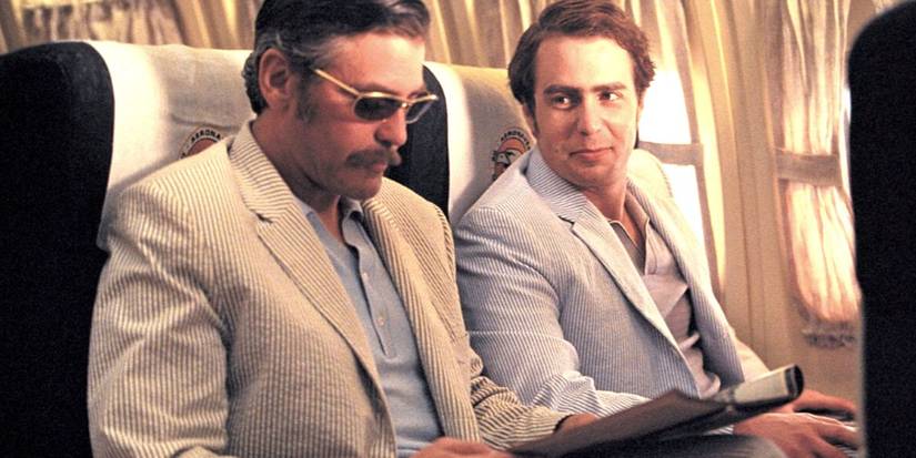 Chuck Barris sits on a plane with a spy contact in Confessions of a Dangerous Mind.