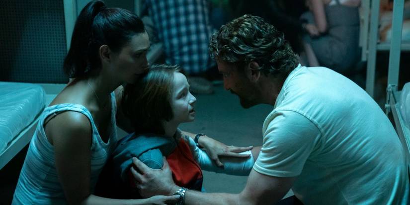 A father consoles his wife and son while the group shelter in a bunker in Greenland.