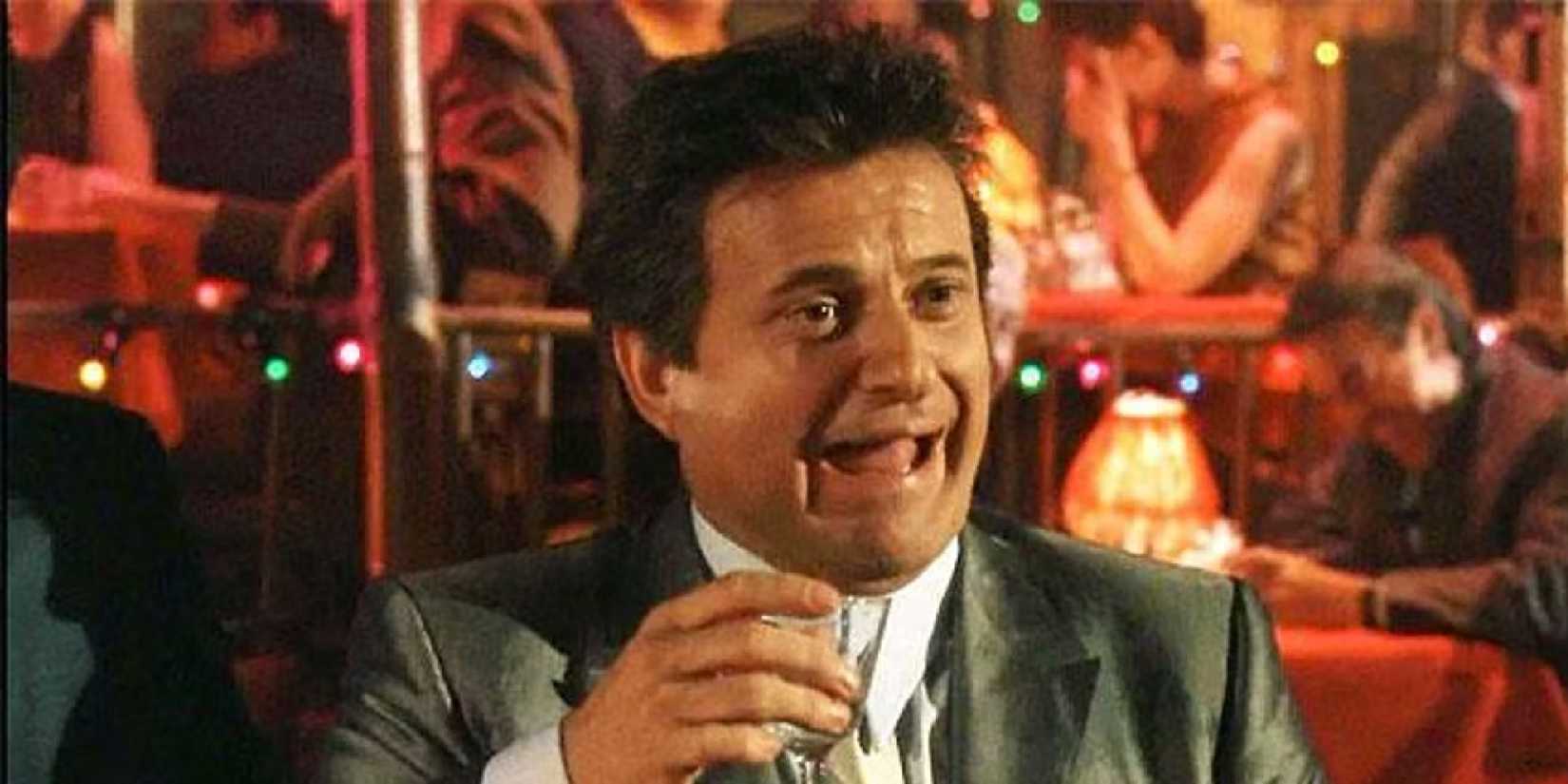 Joe Pesci as Tommy DeVito laughing at a bar in 'Goodfellas'