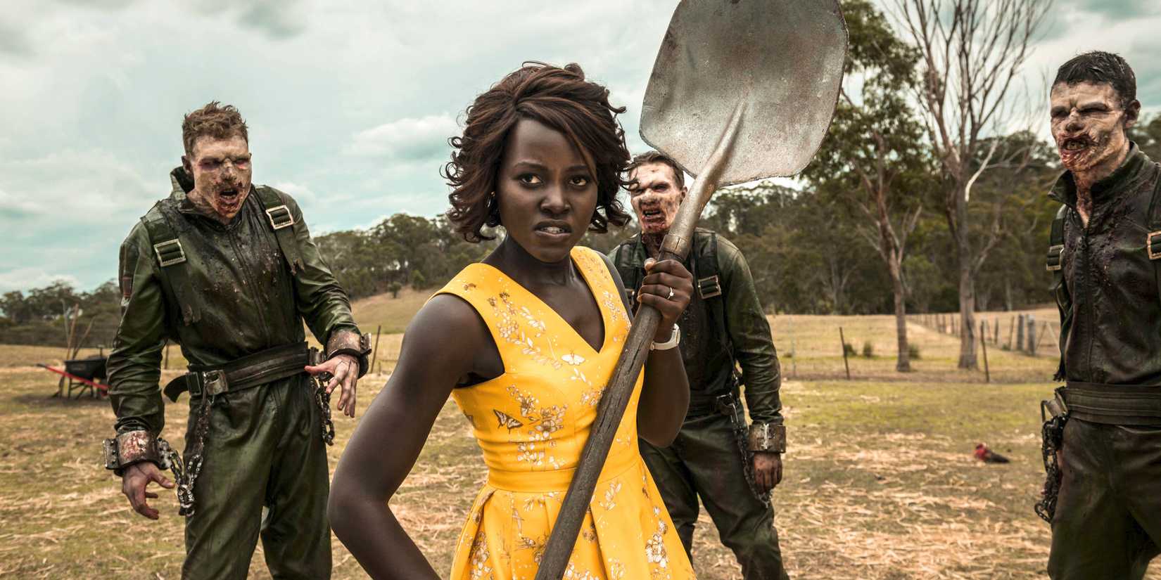 Lupita Nyong'o as Miss Caroline wielding a shovel among zombies in Little Monsters.