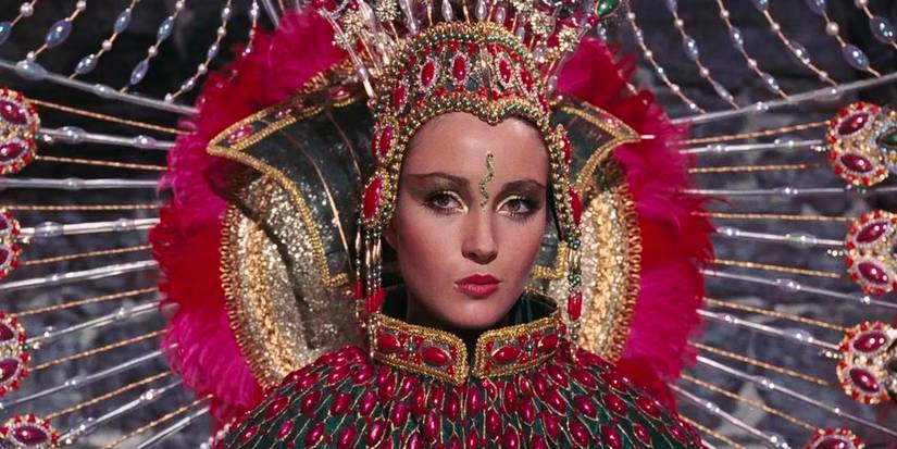 Solitaire (Jane Seymour) wears a vibrant pink outfit. 