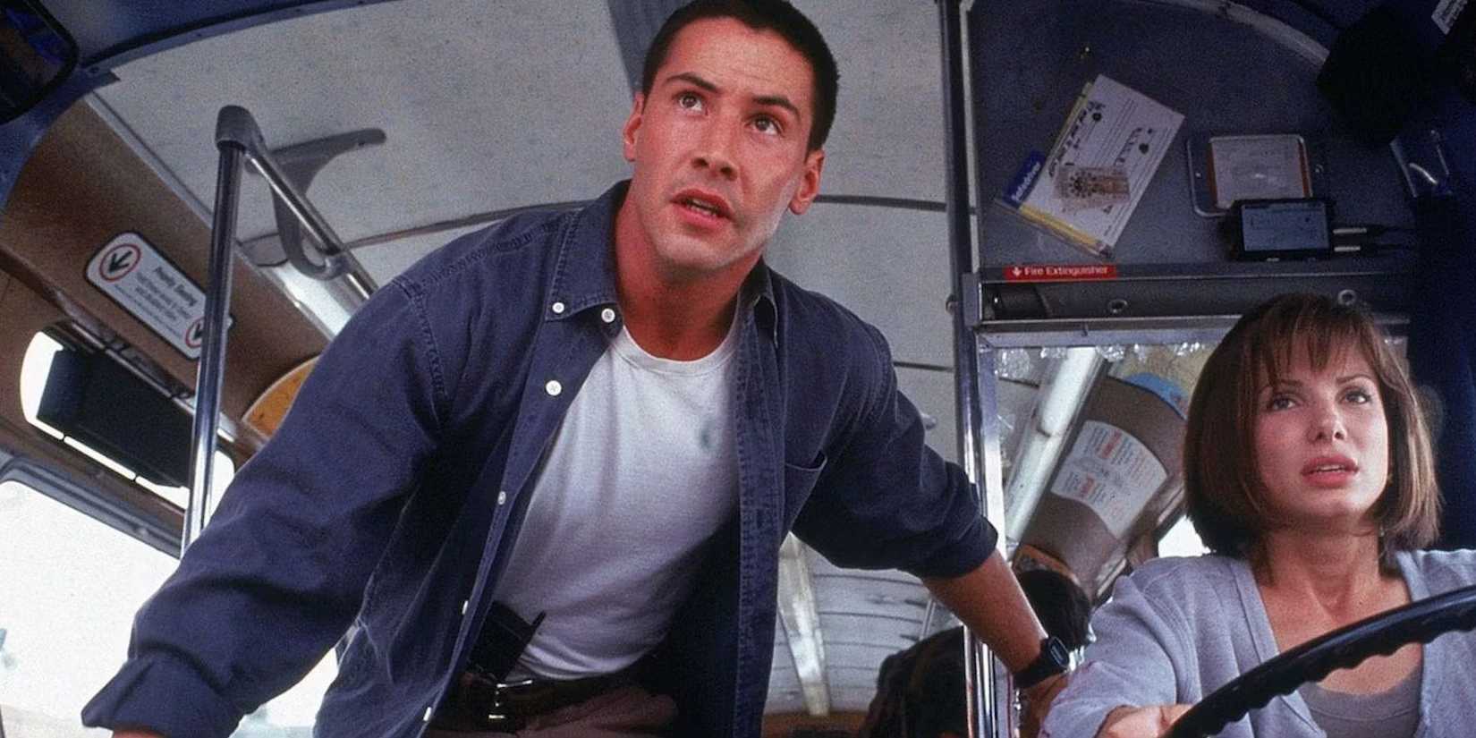 Keanu Reeves looks worried as Sandra Bullock drives a large bus in Speed.