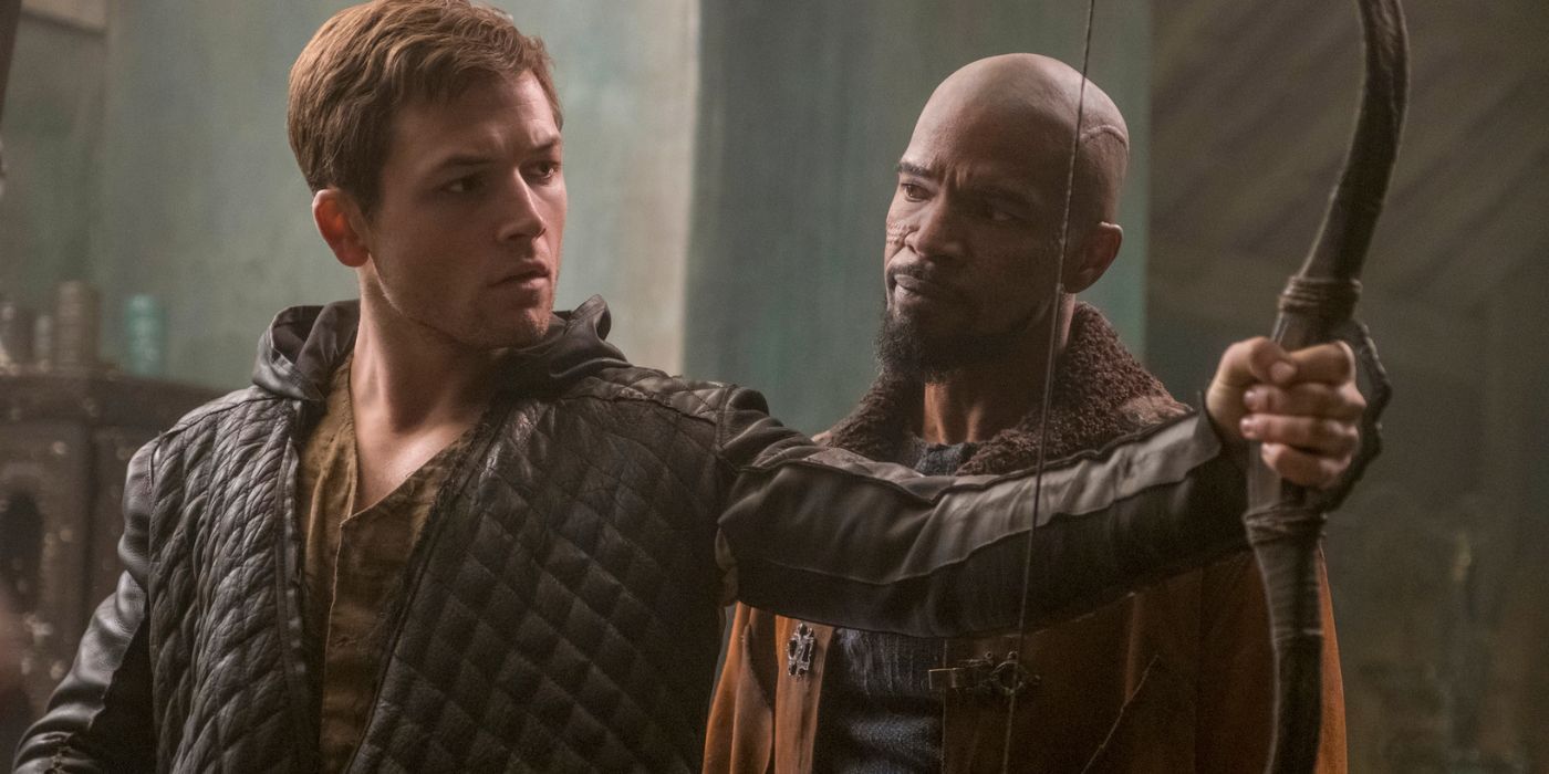 Robin of Loxley holding a bow while Little John stands beside him in Robin Hood